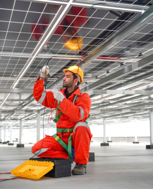 Solar engineer inspecting photovoltaic panels at a solar power installation site